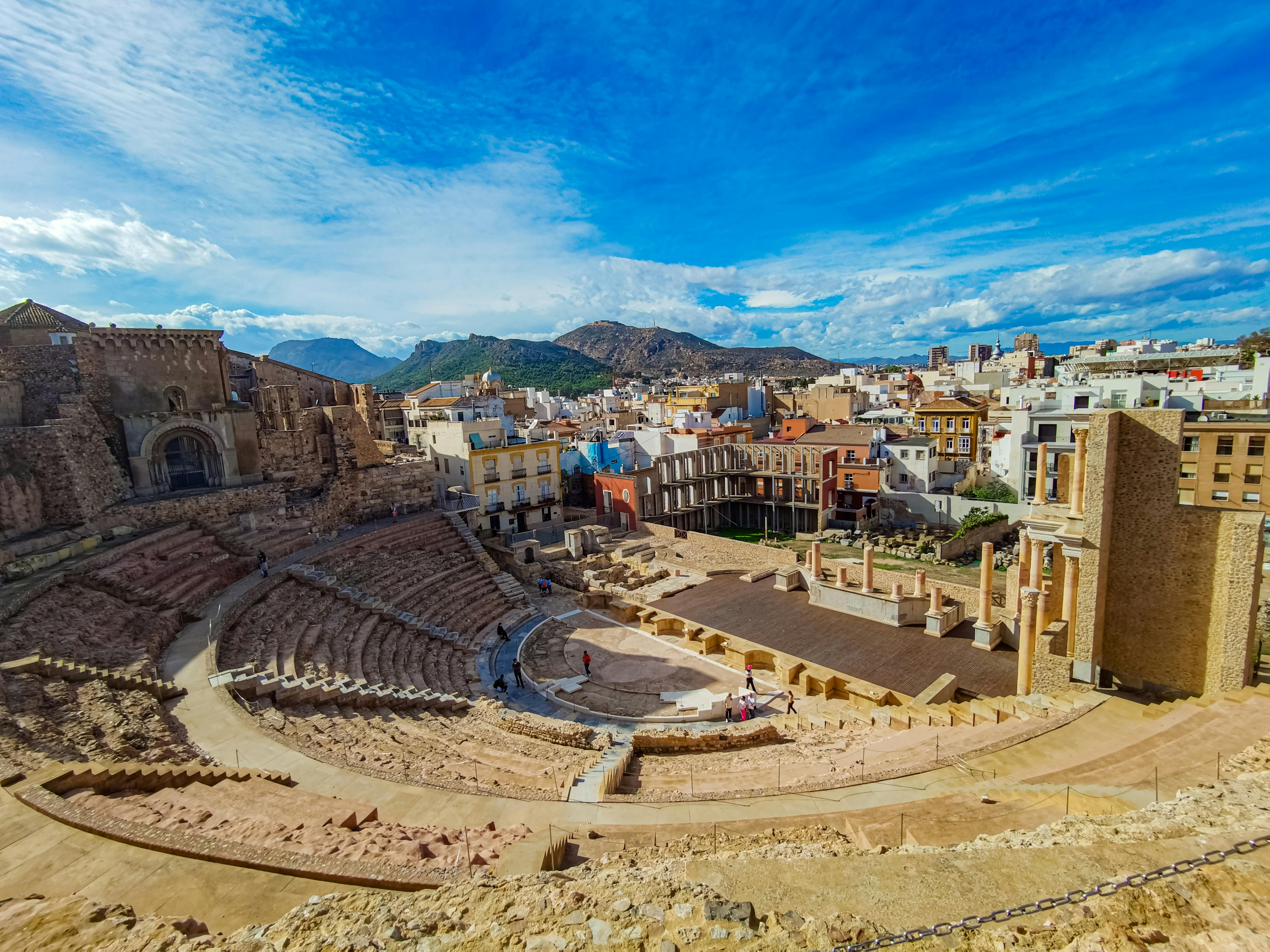 The Roman Theatre in Cartagena, seen from above with the city and hills beyond, one of the most rewarding day trips from Murcia.